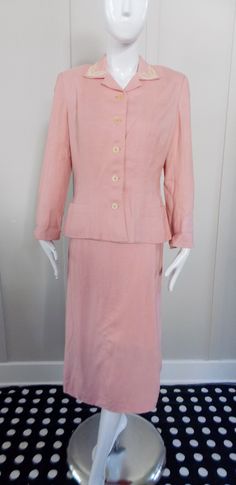 "Pale pink linen suit  Collar is decorated with cream satin stitch embroidery Notched collar Self covered shoulder pads Unlined Seam allowances have been turned under and blind hemmed Bound buttonholes Belt loops but no belt Two front pockets at hem  Turned up wing cuffs Two piece sleeve Princess seaming and darts Skirt has side lapped metal Crown zipper Corded buttonhole and pink button Skirt is unlined and the seam allowances are pinked  Back walking pleat Labelled \"Ever-Lure tailored by Wall Classic Fitted Pink Sets, Pink Skirt Suit For Formal Spring Occasions, Classic Pink Spring Sets, Vintage Pink Spring Sets, Pink Daywear Sets For Spring, Pink Spring Daywear Sets, Vintage Workwear Sets For Spring, Tailored Skirt Suit For Formal Summer Events, Tailored Skirt Suit For Summer Formal Events