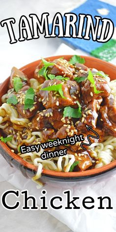 a bowl filled with noodles and meat on top of a white table next to a blue book