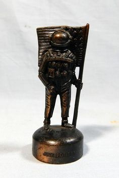 a bronze statue of a man holding a flag on top of a metal base with a white background