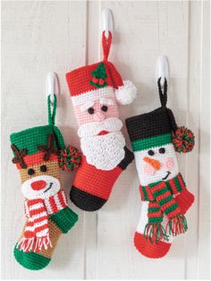 crocheted christmas stockings hanging from hooks with santa and snowman decorations on them