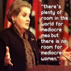 a woman giving a speech at a podium with an american flag in the back ground