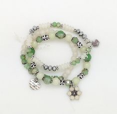 A green, white, silver multi-strand bracelet of three separate pieces.  This multi-strand stretch bracelet set is put together with tiny gemstones like beads and small assorted charms (each piece is very similar, but not exact). #tlb #bohogift #bohemianfashion #BohemianBracelet #HippieBracelet White Jade Beaded Bracelets In Bohemian Style, White Multi-strand Bracelets For Jewelry Making, Green Silver Beads Bracelet, Green Multi-strand Wrap Bracelet As Gift, Green Multi-strand Bracelets For Jewelry Making, Green Multi-strand Beaded Bracelets, Green Multi-strand Beaded Jewelry, Adjustable Green Multi-strand Beaded Bracelets, Bohemian Green Multi-strand Beads