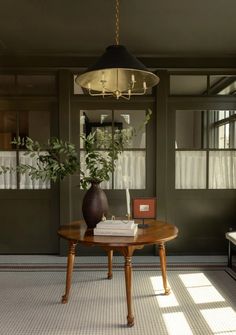 a living room with a table, chair and potted plant