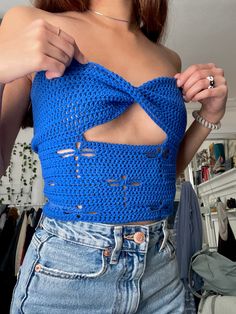 a woman wearing a blue crochet top with cutouts on the front and back