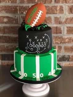 a three tiered cake with a football on top