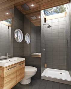 a bathroom with two round windows above the sink and toilet area, along with a walk in shower