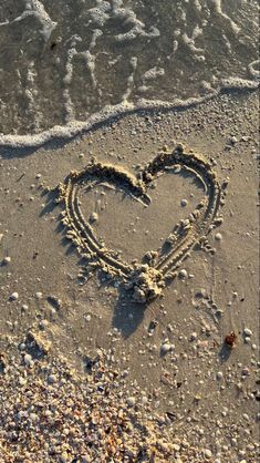 a heart drawn in the sand at the beach