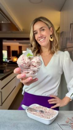 a woman holding up a bowl of ice cream