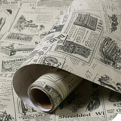 a roll of newspaper sitting on top of a white table next to a wallpaper