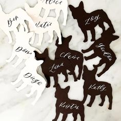 six dog cutouts with names on them sitting on a marble countertop in the shape of dogs