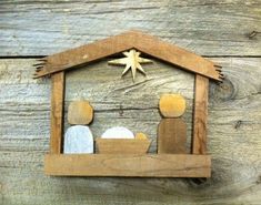 a nativity scene made out of wood with two men and a baby in the manger