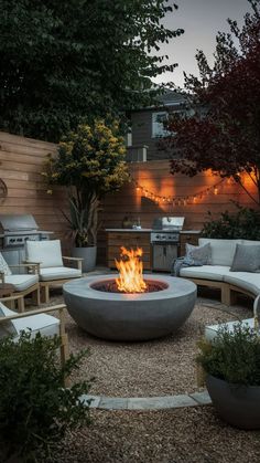 an outdoor fire pit surrounded by chairs and trees