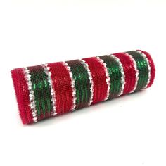 a roll of red, green and white christmas ribbon on a white background with space for text