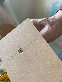 a person holding a piece of cardboard in their hand