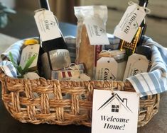 a wicker basket filled with wine bottles and personalized tags that say welcome home