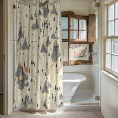 a bathroom with a shower curtain, toilet and bathtub in the corner next to an open window