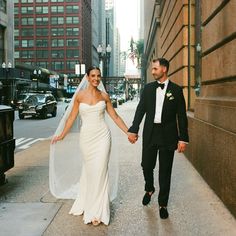 a bride and groom holding hands walking down the street in new york city, ny