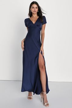 a woman in a long blue dress with a slit down the side and one leg