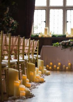 rows of chairs with candles on them in front of a window