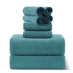 four towels stacked on top of each other in teal green color with rolled ends