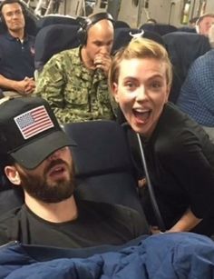 two men and a woman sitting on an airplane with american flags on their visors