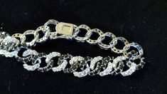 A glittering piece of elegance at a reasonable price. Perfect for those occasional events where glamour is a necessity, but cost is an issue. This bracelet will stand up to the best of them with its intertwined circles of white and black well cinched stones. The bracelet measures approx. 7 ½   inches and weighs 0.88 oz. The circles are 1/2  inches in diameter. .Please look at my pictures carefully as they are an important part of the description. Silver Diamond Cut Bracelet For Party, Party Diamond Cut Tennis Bracelet, Diamond Accented Round Bracelets For Party, Diamond Accents Round Bracelets For Party, Round Diamond Accented Bracelets For Party, Formal Bracelets With Black Diamonds, Round Bracelets With Diamond Accents For Party, Party Silver Diamond Cut Bracelet, Silver Tennis Bracelet With Black Diamonds For Formal Occasions