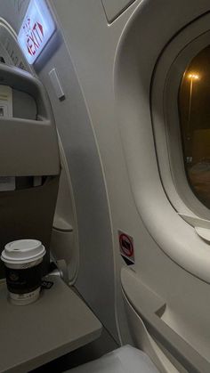 an empty airplane seat with a cup of coffee on it