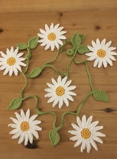 several crocheted flowers on a wooden surface