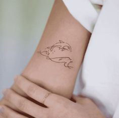 a woman's arm with a small tattoo design on the left side of her wrist