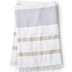 the white and grey striped towel is folded on top of each other, with fringes