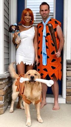 a man and woman in costumes standing next to a dog