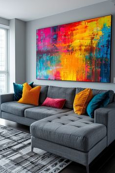 a living room with a large painting on the wall and colorful pillows in front of it