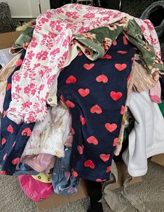 a pile of clothes sitting on top of a cardboard box