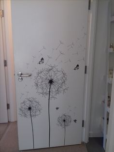 a white door with black dandelions painted on the front and side doors,