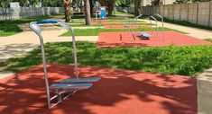 an empty playground with swings and benches in the park