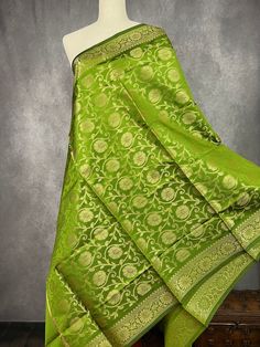 Mehndi Green Banarasi Soft Silk Dupatta with Zari Weaved with flower designs all over the dupatta. Note - Dupatta has black tassels on the ends. Item: DupattaBase color : Mehndi Green (Heena Green Color)Fabric : Banarasi Silk (Non-Pure Silk)Work : Zari Weaved with tasselsWidth of the dupatta - 35 inches (approx)length of the dupatta - 88 inches (approx) Store Policies- No return or exchange will be accepted for color variations.- No return or exchange will be accepted if the color does not match your other clothing or your partners or anyone else.- Since this Dupatta is handmade hence little inconsistencies may be there however it is not considered as a defect.- Zari or thread coming out at the ends or anywhere on the dupatta or on folds is not considered as defects.- Slight variation in a Diwali Chanderi Blouse Piece With Tilla, Festive Chanderi Blouse Piece With Tilla Details, Transitional Green Lehenga For Puja, Green Semi-stitched Traditional Wear With Tilla, Semi-stitched Chanderi Saree With Tilla, Semi-stitched Chanderi Saree With Tilla Detailing, Chanderi Saree Semi-stitched With Tilla, Green Wedding Saree With Tilla Details, Green Wedding Saree With Tilla Work