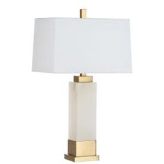 a white lamp with a gold base and a white shade on the top, sitting against a white background