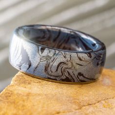 a black and white ring sitting on top of a rock