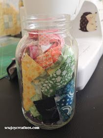 a glass jar filled with different types of fabric