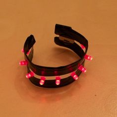 a pair of black and pink lights up headbands on top of a table