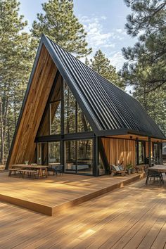 a house with a pitched roof and wooden decking in the middle of a forest