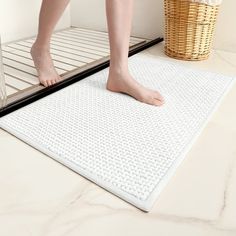 a person standing on a mat in front of a bathroom mirror with their feet propped up