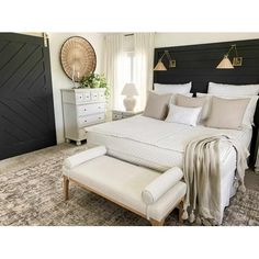 a bedroom with a large bed, white furniture and pillows on top of the bed