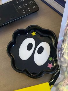 a black plate with white eyes and stars on it next to a bag of candy