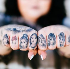 a woman's hand with tattoos on it and her fingers in the shape of faces