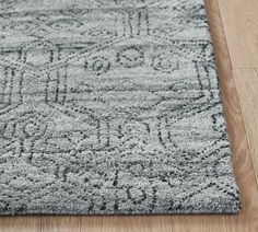 a gray rug with an intricate design on the floor