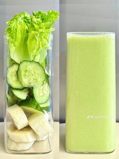 a glass filled with cucumber and lettuce next to a container