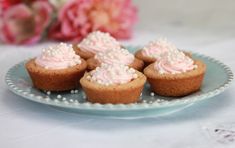 small cupcakes with pink frosting and sprinkles on a plate