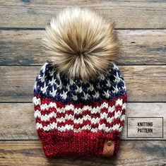 a red, white and blue knitted hat with a pom - pom