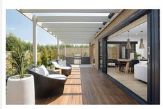 an outdoor living area with wooden flooring and white furniture